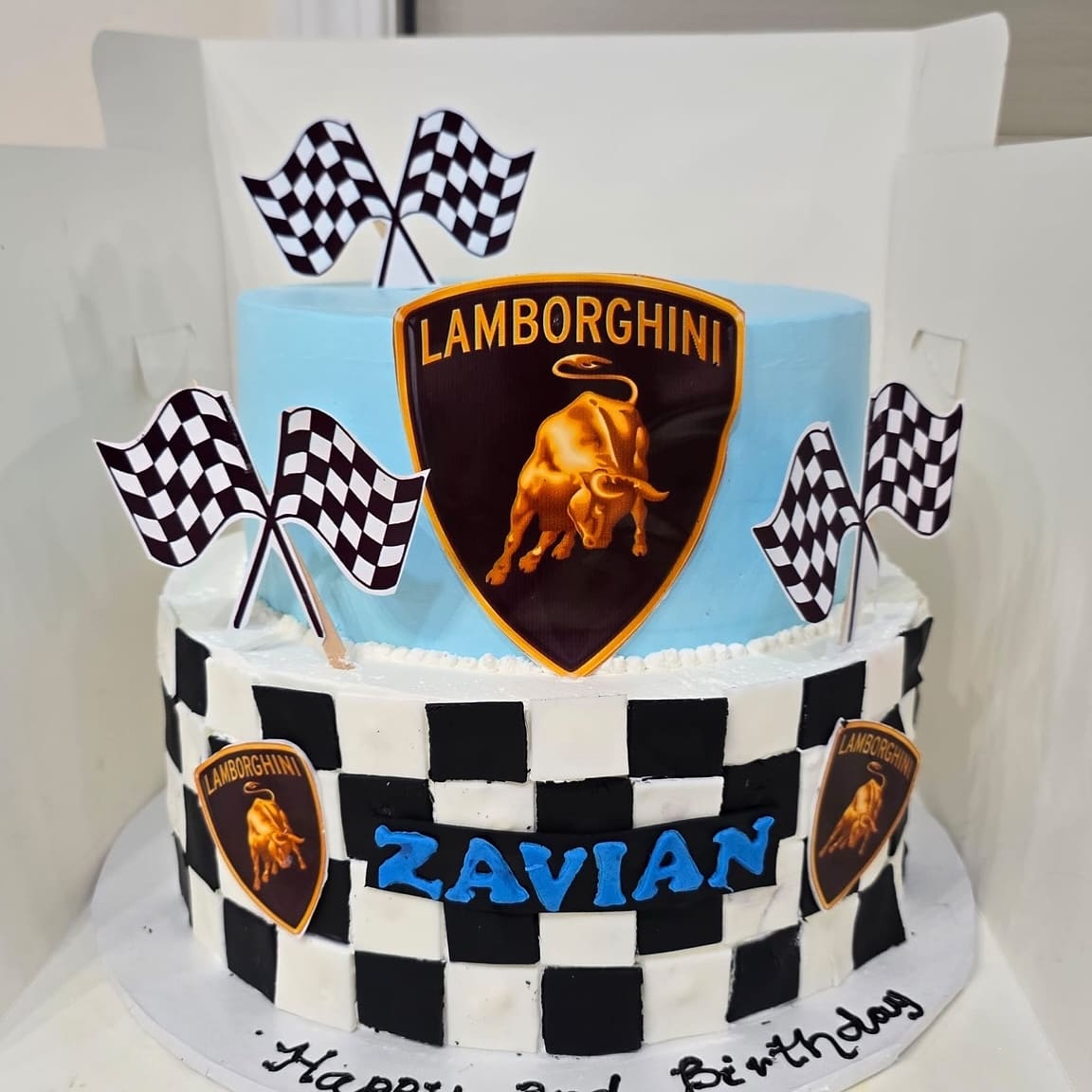 Two tier racing cake with chequered flags and a black and white chequered tier for a third birthday