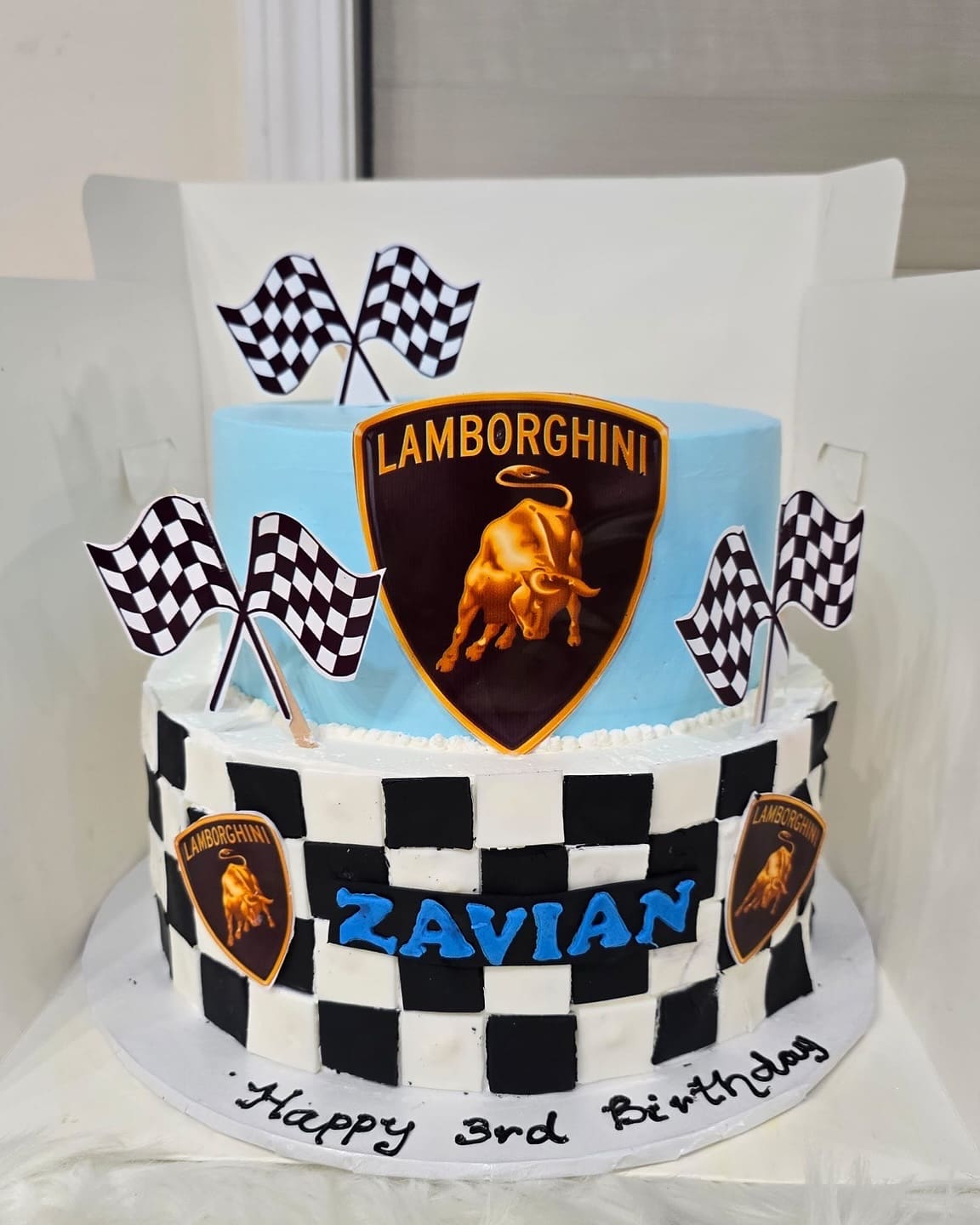 Two tier racing cake with chequered flags and a black and white chequered tier for a third birthday