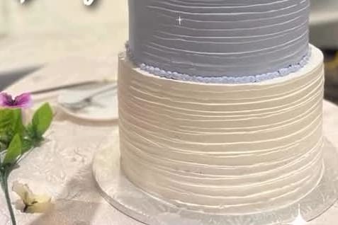 Combed buttercream tiers in white and soft grey on a tall wedding cake